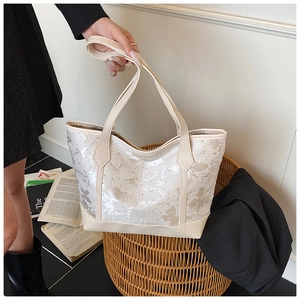 Detail of butterfly pattern and shimmering glitter on beige tote bag surface