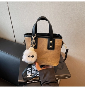 Gros plan du sac seau en toile marron avec bordure noire et breloque en peluche