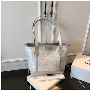 Detailed embroidery of flowers and butterflies on a silver-grey luxury tote bag