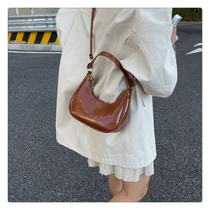 Détail du sac demi-lune marron caramel avec texture cuir glacé de qualité et bandoulière