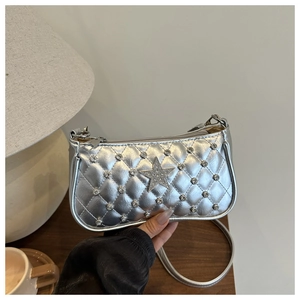 Détail du sac bandoulière argenté matelassé avec étoile en strass et finition métallique