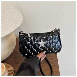 Vue détaillée du sac en cuir verni noir avec étoile en strass argentés et motif matelassé