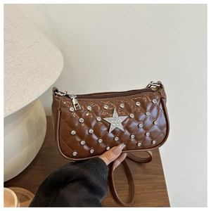 Détail macro du sac porté épaule matelassé marron avec étoile argentée et strass