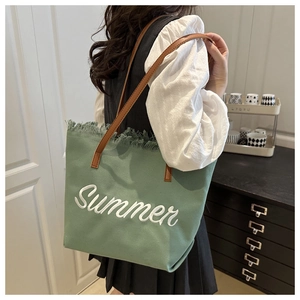 Dettaglio borsa tote in tela verde menta con ricamo Summer e manici in pelle