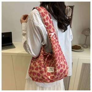 Detail view of pink leopard heart print tote bag with wide strap knot and logo tag