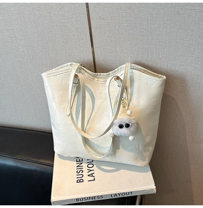 Détail du sac cabas blanc crème avec gaufrage floral 3D et charmant monstre en peluche