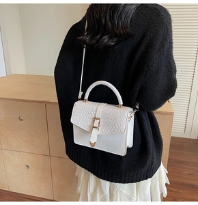 Vue arrière du mannequin portant un sac à bandoulière blanc en similicuir façon crocodile
