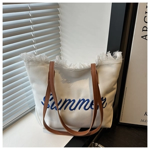 Détail du cabas en toile blanche avec broderie Summer bleue et bords effilochés