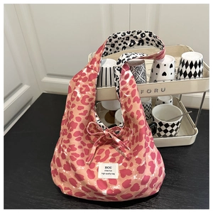 Detail of pink canvas tote bag with leopard print lining and decorative bow tie