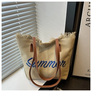 Détail de la broderie Summer et du bord effiloché sur le sac fourre-tout en toile