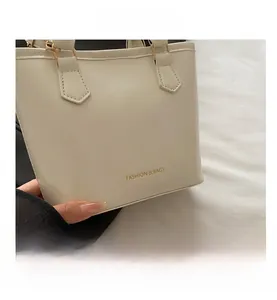 Macro view of cream white faux leather tote bag with gold FASHION & BAGS lettering