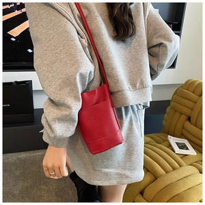 Dettaglio della mini borsa a secchiello in pelle martellata rossa con tasca frontale