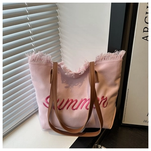 Détail du sac cabas en toile rose avec broderie Summer et bords à franges chics