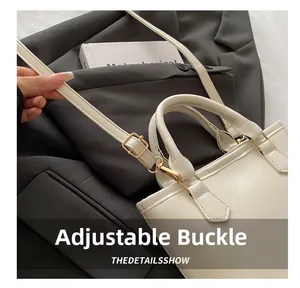 Detail view of the white leather bucket bag showing adjustable strap and gold buckle