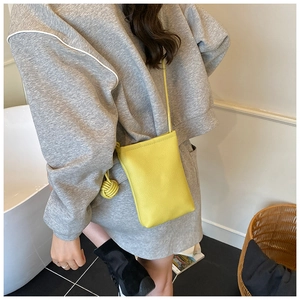 Detail of yellow lychee texture phone bag with creative leather knot on shoulder strap