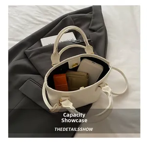 Practical internal capacity of the white leather bucket bag showing phone and wallet storage