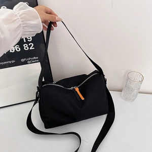 Large black nylon shoulder bag with orange zipper details in a retro Japanese postman style