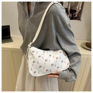 Detailed view of floral shoulder bag with colorful prints and white leather strap