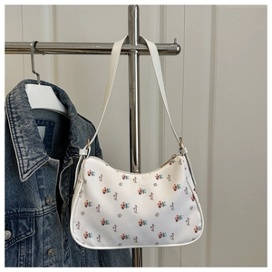 Detail of white floral armpit bag with colorful flower patterns and metal zipper closure