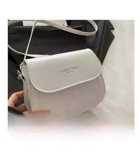 Detail of white saddle bag showing diamond quilt pattern and FASHION TREND embossed text