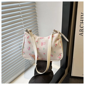 Detail of floral underarm bag with rose prints, bow design, and adjustable strap