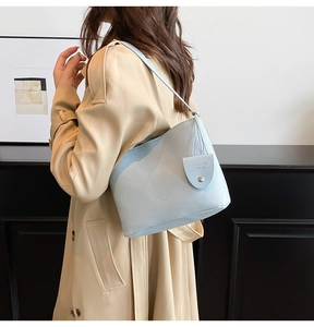 Detail of light blue lychee pattern bucket bag with brand embossing and leather tag