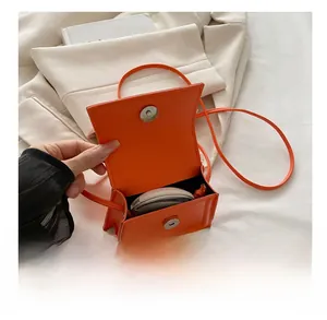 Internal view of mini orange leather bag showing capacity for small essentials