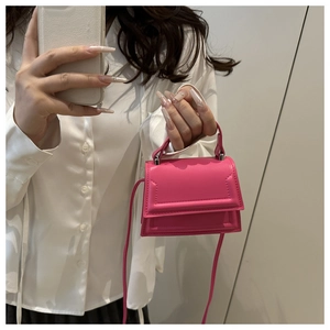 Close-up of rose pink mini crossbody bag with top handle and silver hardware