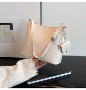 Detailed texture of white lychee leather hobo bag with a round mini coin purse detail