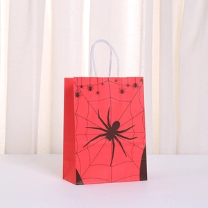 Detail of red Halloween kraft bag with black spider web pattern and paper handles