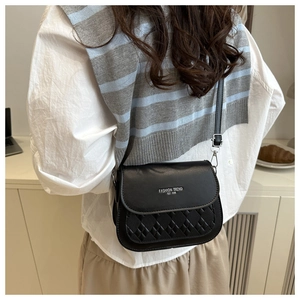 Détail du sac bandoulière noir avec texture cuir matelassée et lettrage argenté