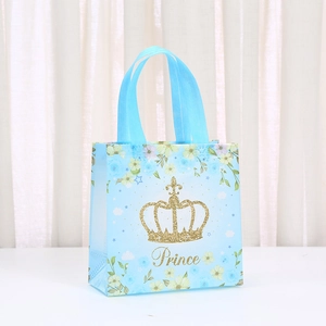 Detail of light blue Prince gift bag with gold glitter crown and ribbon handles