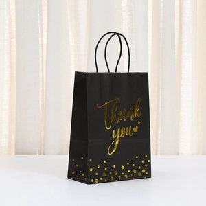 Bolsa de regalo de papel kraft negro con texto en pan de oro y asas de cuerda negra