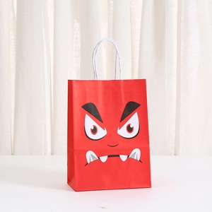 Detail of red Halloween paper gift bag with angry monster face and white rope handle