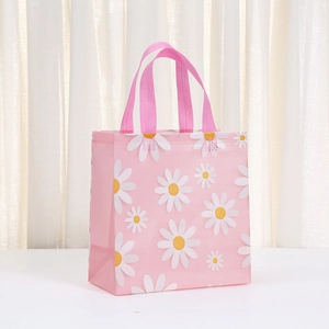 Pink non-woven gift bag with white daisy prints and matching fabric handles for shopping