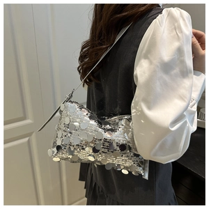 Detail of silver sequin shoulder bag showing shimmering metallic texture and slim strap