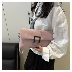 Detail view of pink suede shoulder bag with leopard print and matte black square buckle