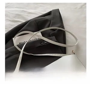 Close-up of the adjustable white leather shoulder strap and fine gold metal hardware