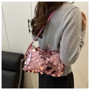 Close-up of pink sequined shoulder bag showing glossy reflective texture and slim strap