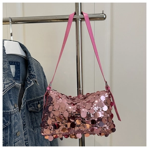 Detail of pink sequins on a shoulder bag with adjustable leather strap in close-up