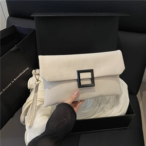 Modern off-white baguette bag with a bold black square buckle in a luxury gift box