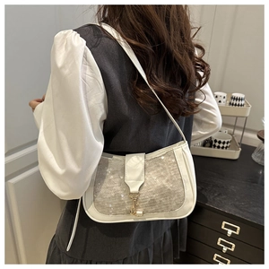 Detail of white sequined armpit bag with gold hook clasp on soft leather strap