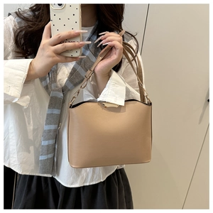 Mirror selfie showing the beige leather shoulder bag with gold clasp on a model