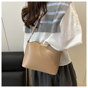 Detail of light brown leather shoulder bag with gold hardware and adjustable strap