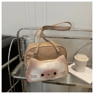 Close-up of beige leather bag featuring 3D plush cat pocket on a glass shelf