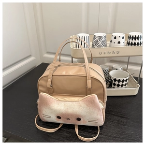 Close-up of beige cat pattern backpack with plush pocket on a wooden tabletop
