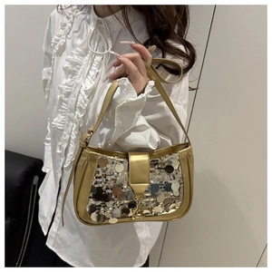 Gros plan du sac baguette doré orné de grandes paillettes rondes scintillantes