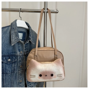 Detail of cute cat shaped front pocket on beige tote bag with soft kitten features