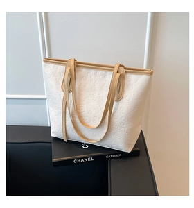 Détail du sac cabas crème avec motifs d'ours gaufrés et finitions en cuir marron
