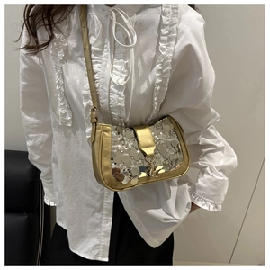 Détail d'un sac baguette à paillettes dorées avec bandoulière réglable et fermoir métal